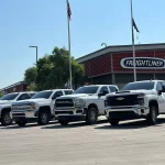 a row of white trucks in front of a building