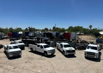 a group of white trucks parked in a parking lot